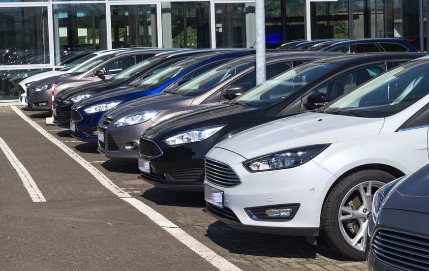 row of cars parking in the dealership bay.