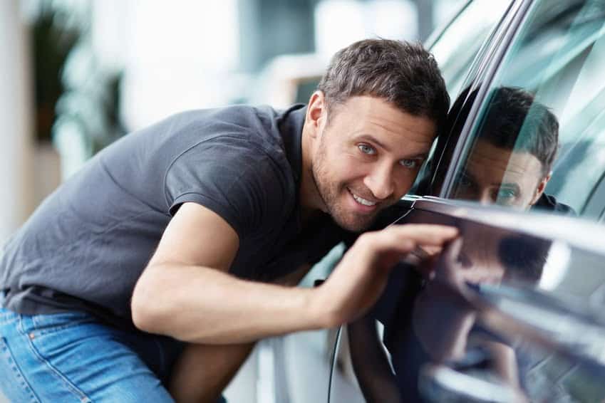 Male examining a car closely