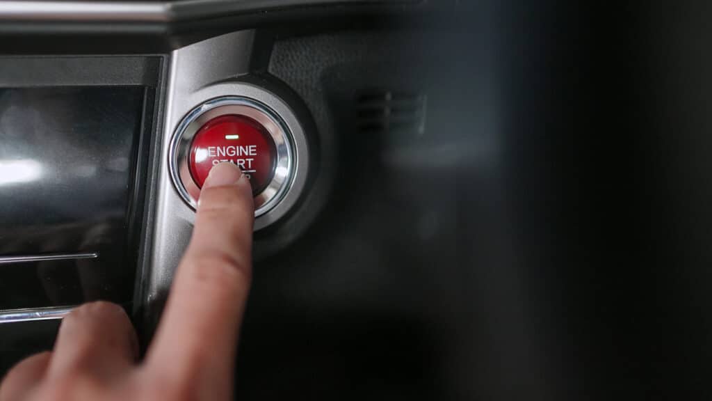 A man push engine start button. Start a car and ready to go.