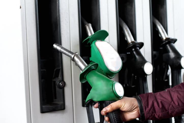 Person lifting fuel pump to fill fuel in car