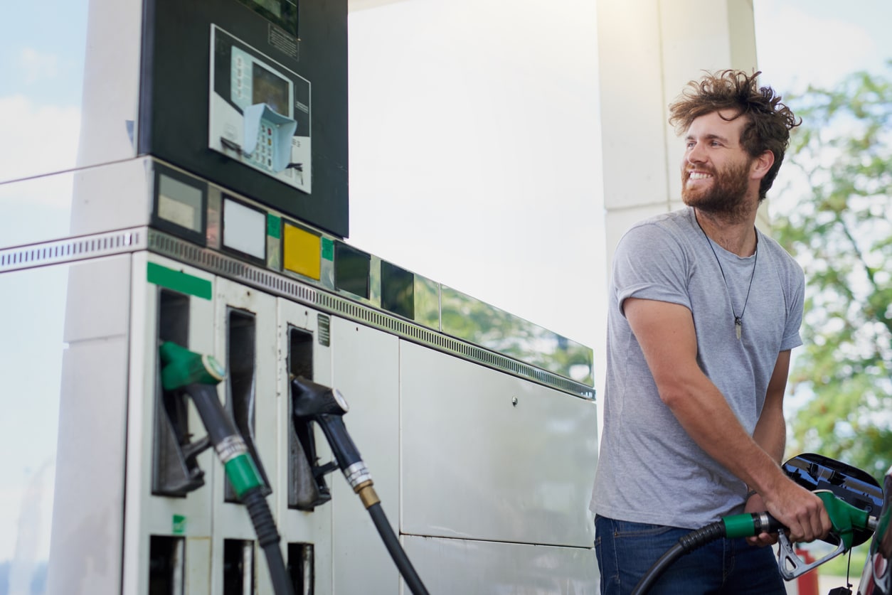 Cropped shot of a handsome young man refuelling his car at a gas station